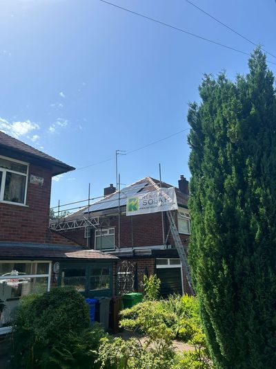 Wide view of a residential solar panel installation on a traditional brick property